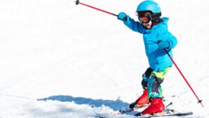 Jeune enfant en combinaison de ski entrain de skier
