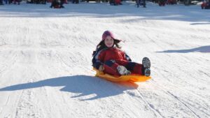 Enfant qui glisse sur la neige en luge